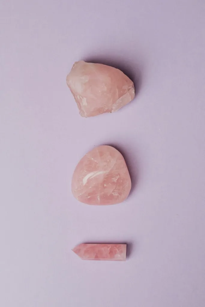 Üç farklı formda pembe kuvars taşı: ham, cilalı ve uç şekilli.
