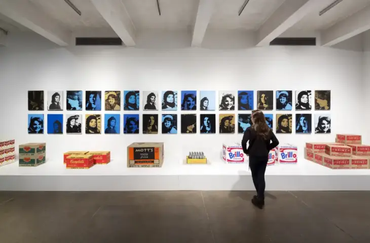 Andy Warhol’un pop art portreleriyle çevrili sergi duvarı; Campbell’s, Brillo ve Heinz gibi ikonik ürün kutularıyla birlikte modern sanatın tüketim kültürüyle buluştuğu bir galeri alanı.