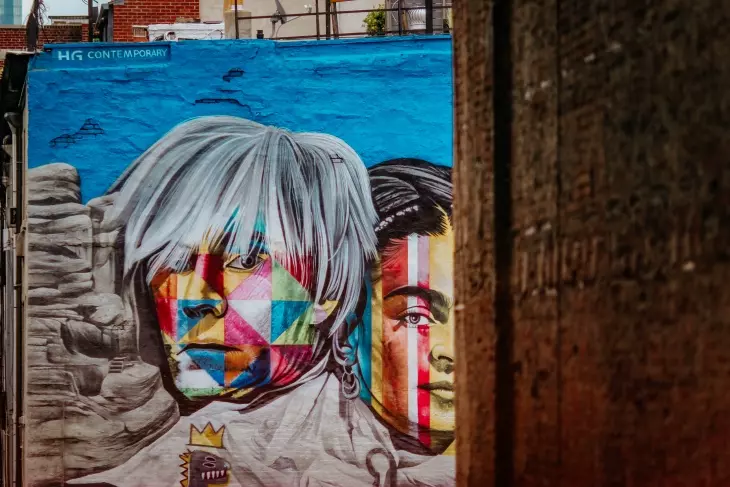 Andy Warhol ve Frida Kahlo portrelerini geometrik renk bloklarıyla birleştiren dış cephe duvar resmi.