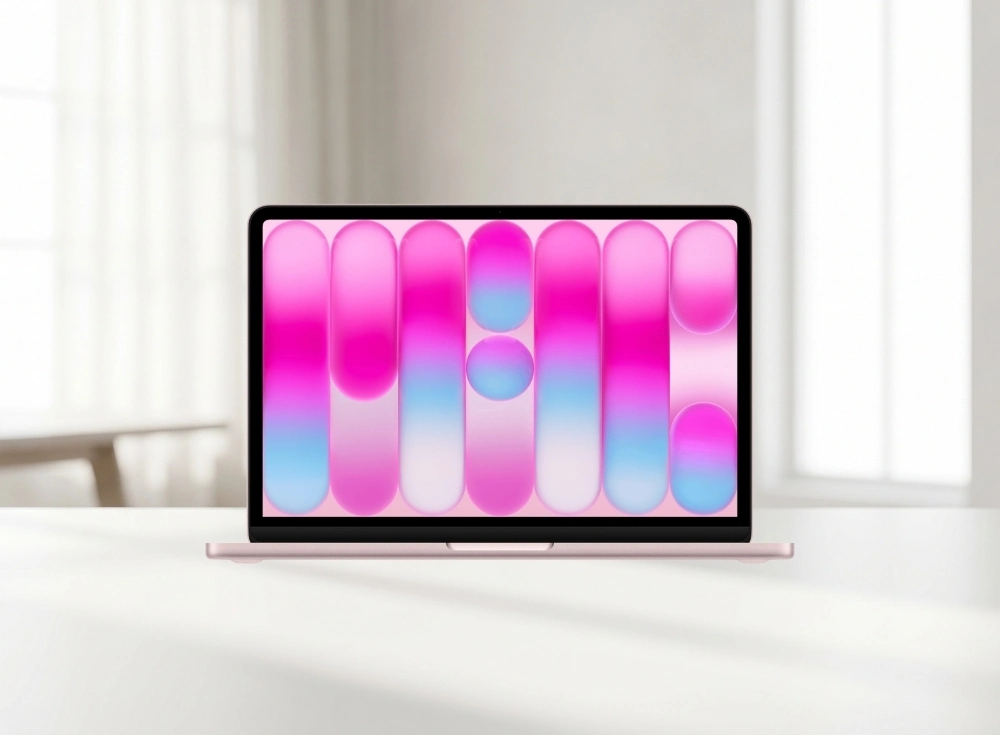 Parlak pembe ve mavi tonlarında dikey ve dairesel soyut şekillerin olduğu bir duvar kağıdı gösteren ekranı açık, gül kurusu rengi Apple MacBook Neo dizüstü bilgisayarı, A18 Pro çipi ve yapay zekâ desteğiyle günlük kullanımda yüksek performans ve mobil güç sunarak aydınlık bir masada zarifçe konumlanmış.