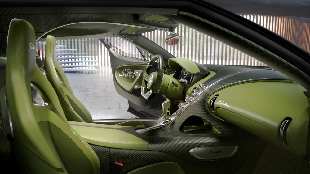Bugatti Brouillard Programme Solitaire adlı yeşil hiper otomobilin, açık yeşil derilerle kaplı spor koltukları, direksiyonu ve torpidosuyla karbon fiber detayları birleştiren lüks ve modern iç mekan tasarımı.