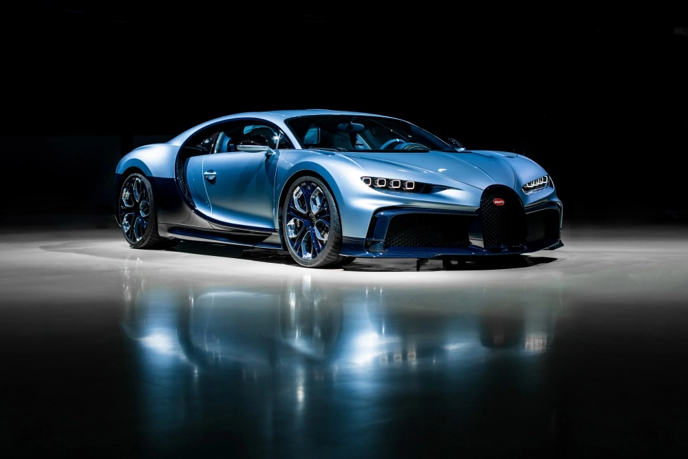 Karanlık ve yansımalı bir zeminde tüm ihtişamıyla duran, buz mavisi renkteki aerodinamik tasarımlı Bugatti Chiron Profilee hiper otomobil, dünyanın en pahalı arabaları listesindeki yerini vurgulayan detaylarıyla göz kamaştırıyor.