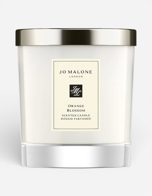 Jo Malone London'un Orange Blossom kokulu mumu, gümüş renkli kapağı ve şık beyaz cam kavanozuyla sunuluyor. Sevgililer Günü için zarif ve lüks bir hediye seçeneği.