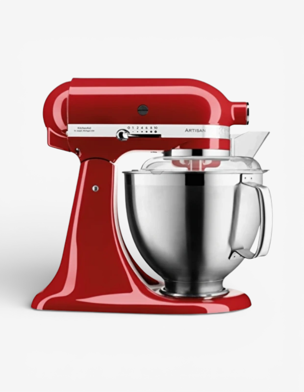 Farklı zevklere özel bir Sevgililer Günü hediyesi olarak sunulan parlak kırmızı KitchenAid Artisan stand mikser, paslanmaz çelik karıştırma kasesi ve sıçrama önleyici kapağıyla gösteriliyor.