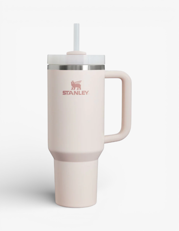 Kulplu ve pipetli açık pembe Stanley termos, Sevgililer Günü için pratik bir hediye seçeneği olarak beyaz arka plan üzerinde sergileniyor.