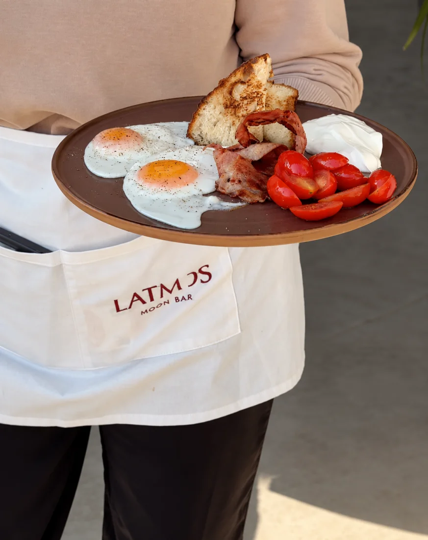 Latmos Athens’te kızarmış yumurta, bacon, kızarmış ekmek ve cherry domateslerle hazırlanan kahvaltı tabağı.