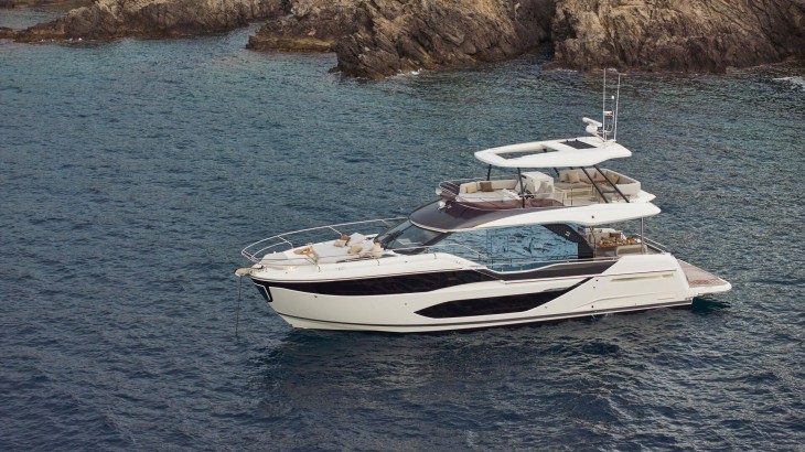 Prestige F5.7 lüks, flybridge, modern motor yat, gündüz vakti doğal bir koya demirlemiş