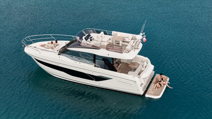Prestige F4.3 giriş segmenti, beyaz renk, flybridge lüks motor yat, arka havuzlukta güneşlenen çift, yaz mevsimi