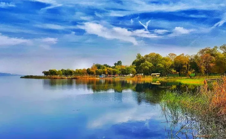 Sapanca Gölü kıyısında yeşillikler ve gökyüzü yansımasıyla huzurlu manzara