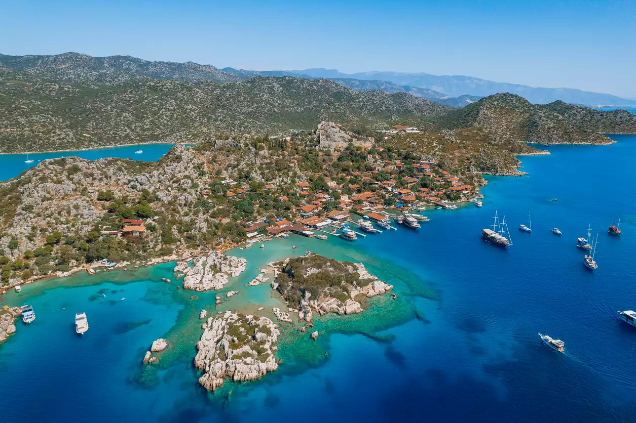Akdeniz'in en güzel şehirlerinden biri olan Antalya'nın berrak turkuaz sularıyla çevrili, kayalık kıyılarda sıralanmış geleneksel evleri ve tarihi dokusuyla büyüleyici bir atmosfer sunan Kekova'yı kuşbakışı gösteren bu fotoğraf, bölgenin doğal ve kültürel zenginliğini vurguluyor.