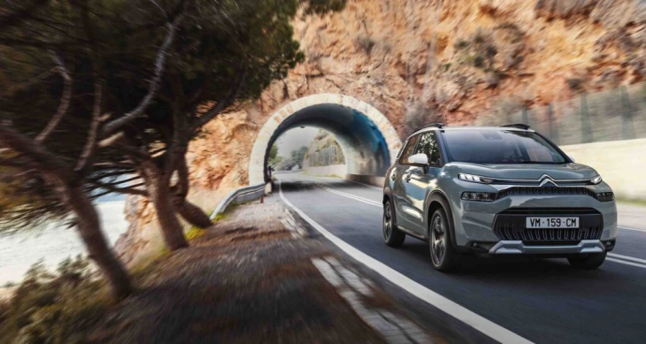 Açık gri renkte bir Citroen C3 Aircross model araba, sahil yolu gibi görünen, kayalık bir alanda bir tünele doğru ilerliyor.