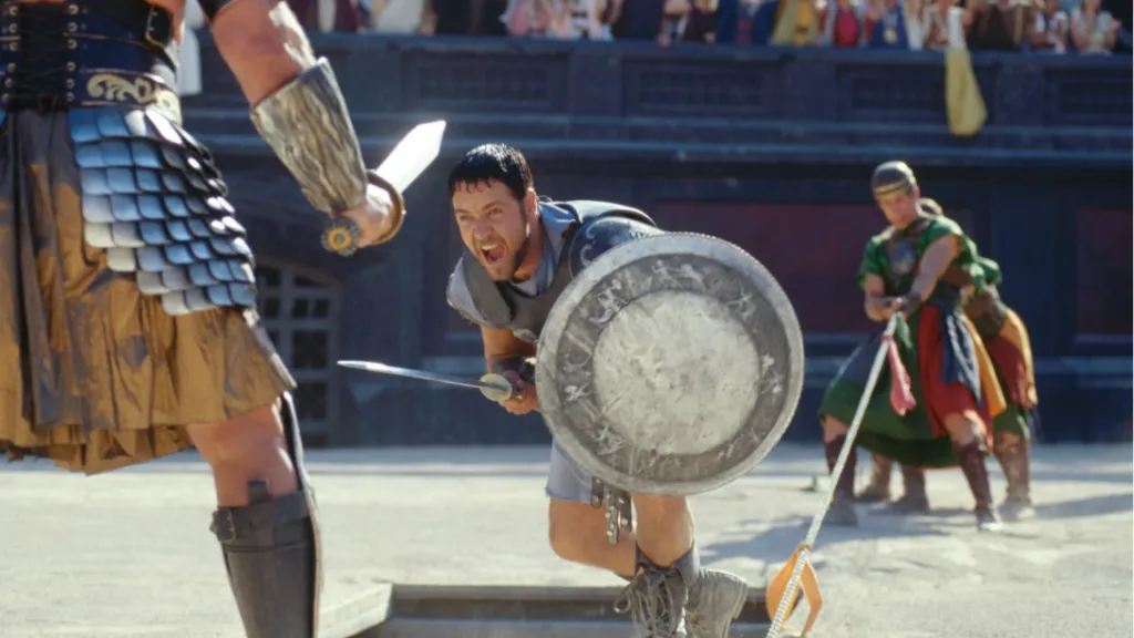 Gladyatör filminden, arenada savaşan zırhlı Russell Crowe’un öfkeli ve destansı dövüş sahnesi.