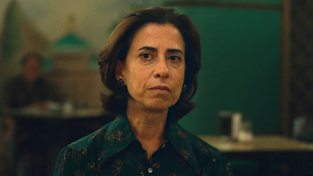 Ainda Estou Aqui (Hâlâ Buradayım) filminden bir sahne: Kadın karakter ciddi bir ifadeyle doğrudan kameraya bakıyor.