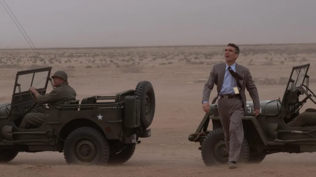 Oppenheimer filminden, çöl ortasında askeri araçların arasında yürüyen Cillian Murphy’nin canlandırdığı J. Robert Oppenheimer sahnesi.