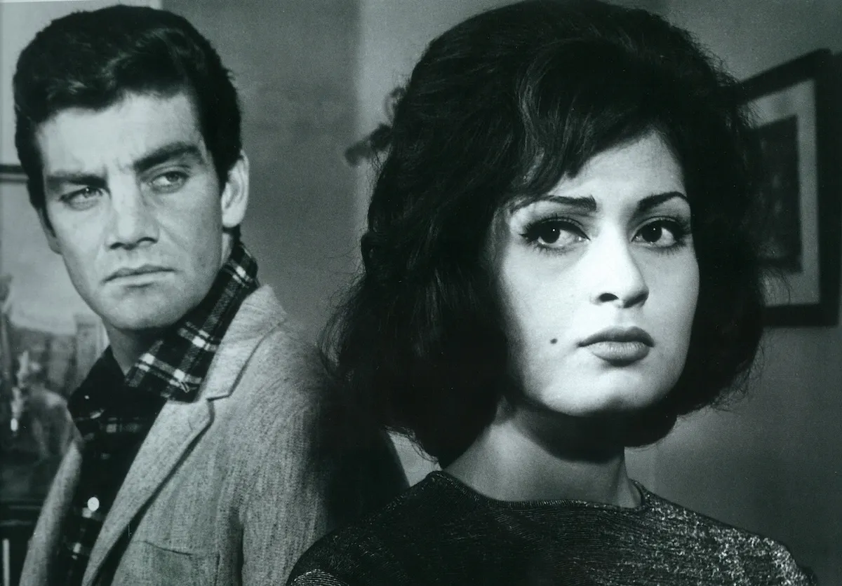 45. İstanbul Film Festivali gösterimi kapsamında Acı Hayat filminden bir kare: Ön planda, sol yanağında beni olan koyu renk gür saçlı, ağır makyajlı, izleyiciye doğrudan bakan dramatik ifadeli bir kadın; arkasında ise hafif bulanık, kareli gömlek ve ceket giymiş, sağa doğru bakan, gergin ve ciddi ifadeli bir erkek yer alıyor.