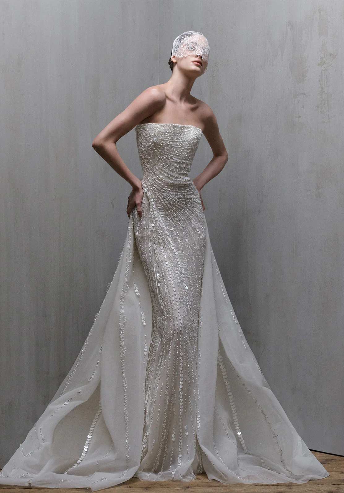 Elie Saab straplez düz yaka, tamamı dikey hatlı payet ve kristal işlemeli, belden eklenen tül pelerin detaylı balık model gelinlik.