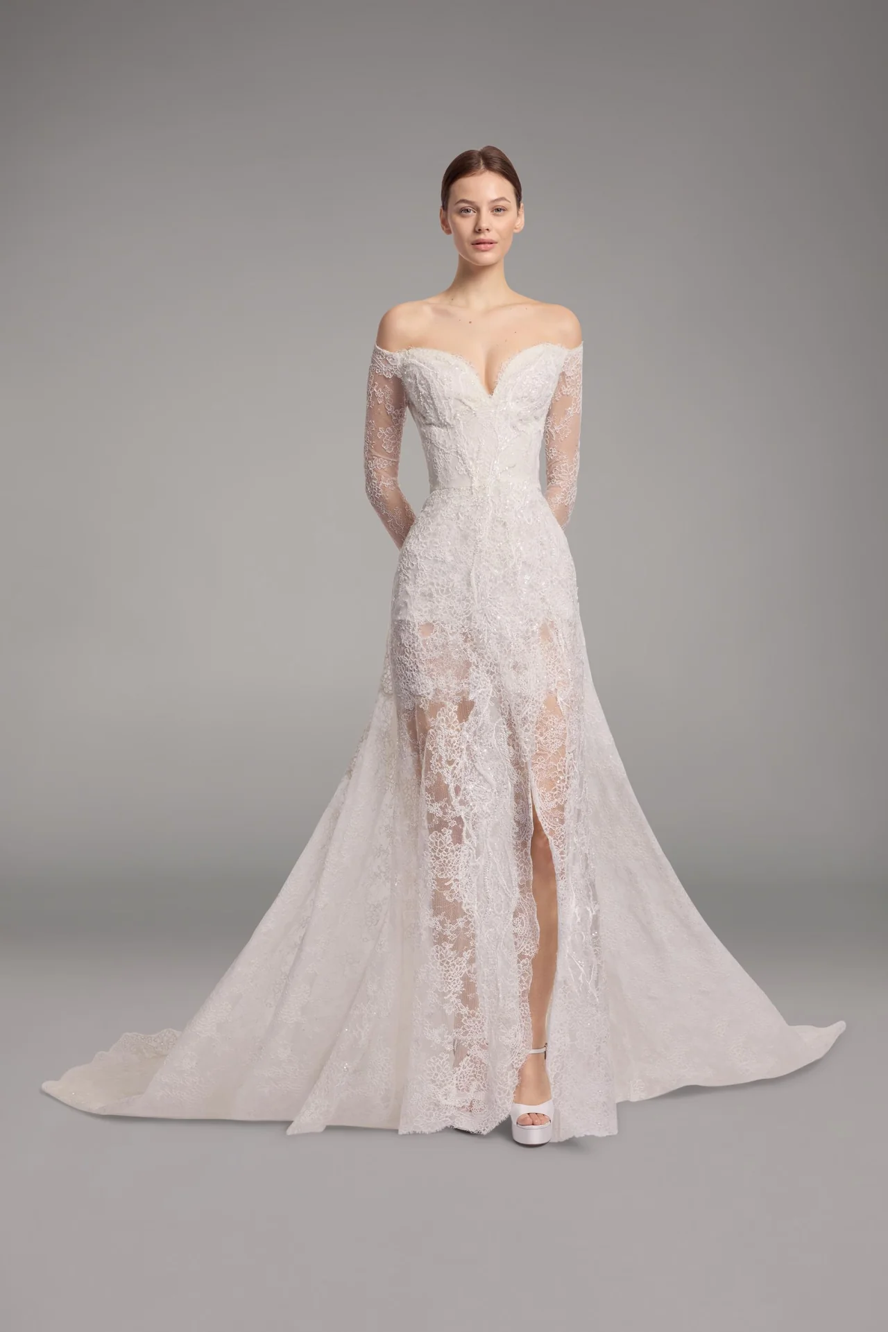 Elie Saab düşük omuzlu, V yaka dekolteli, uzun dantel kollu, tamamı transparan floral dantel işlemeli ve derin bacak yırtmaçlı balık model gelinlik.