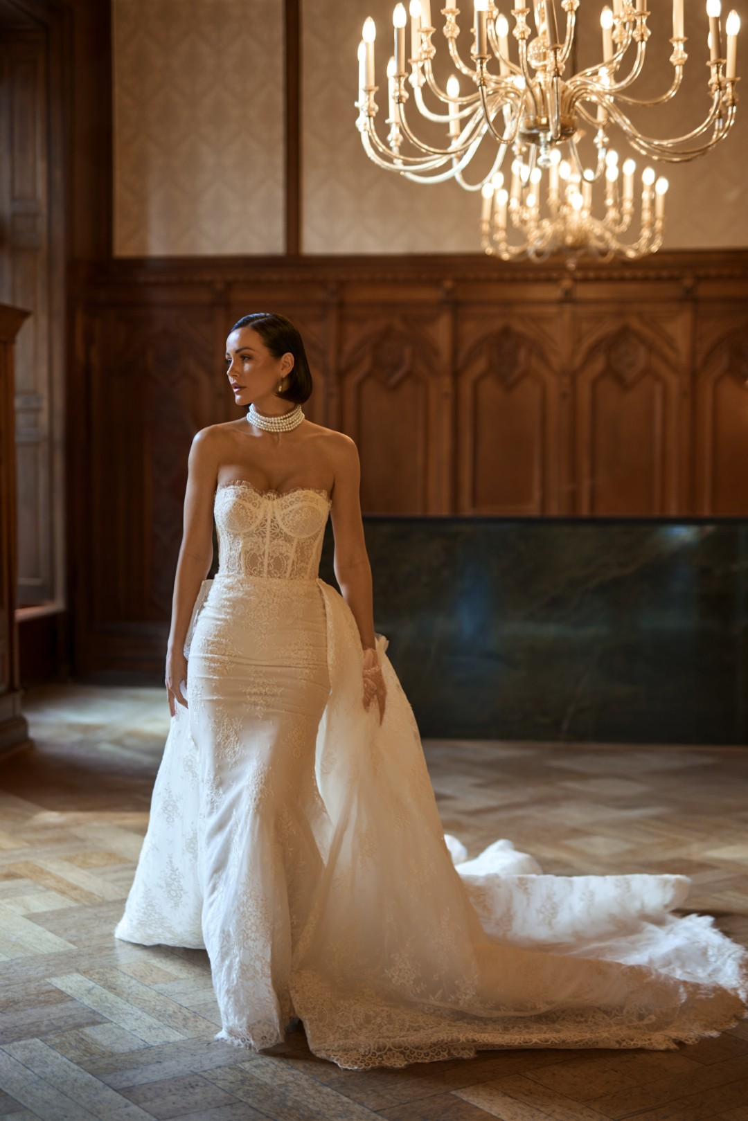 Sima Couture straplez kalp yaka, gövdesi transparan dantel korse yapısında, kalçadan itibaren genişleyen ve arkadan eklenen görkemli dantel işlemeli kuyruğa sahip, tamamı floral motifli dantel kaplı balık model gelinlik.