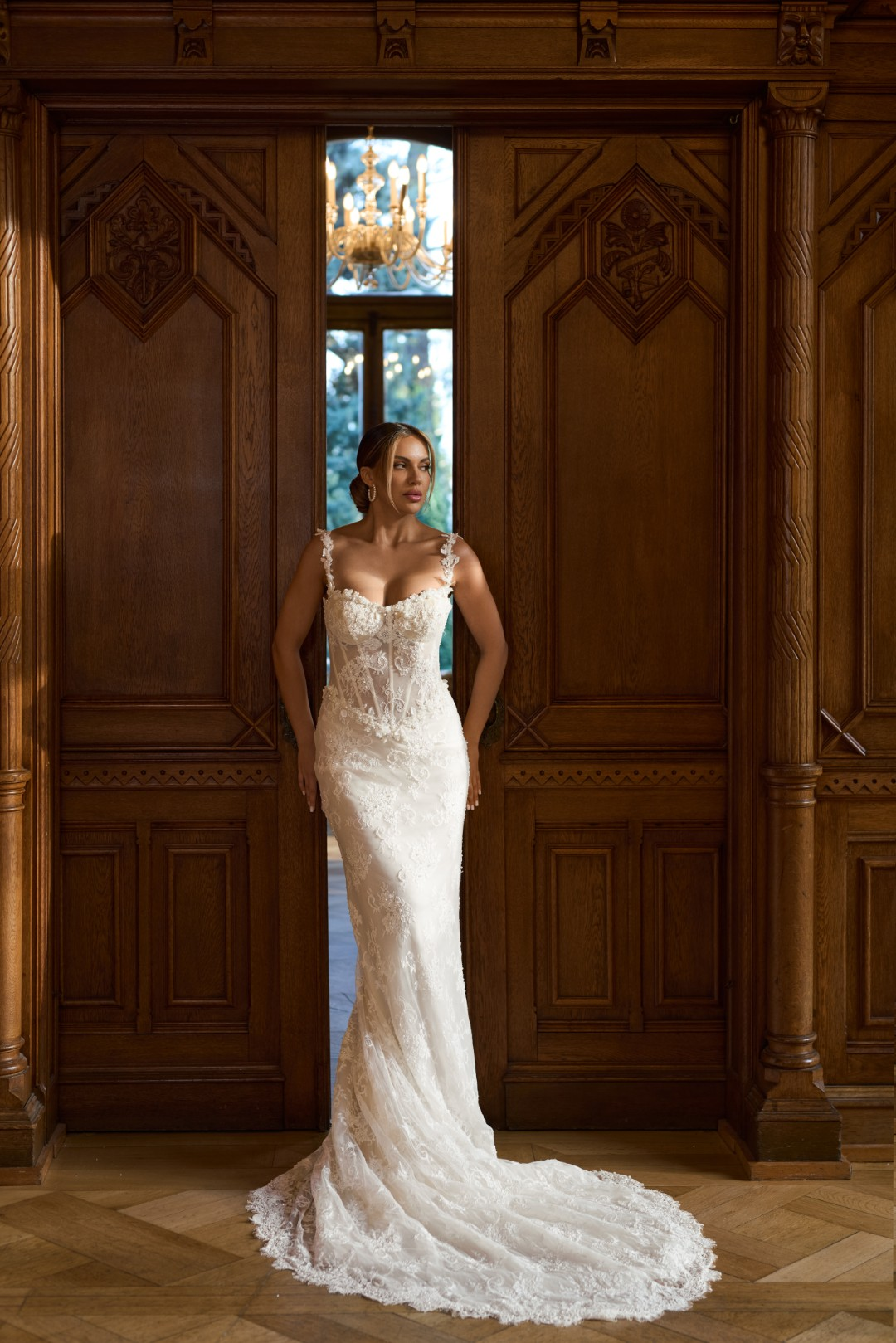 Sima Couture ince askılı, gövdesi transparan ve dikey balenli korse yapısında, göğüs ve bel hattı yoğun ışıltılı taşlarla işlenmiş, tamamı dantel kaplamalı ve zarif kuyruklu balık model gelinlik.