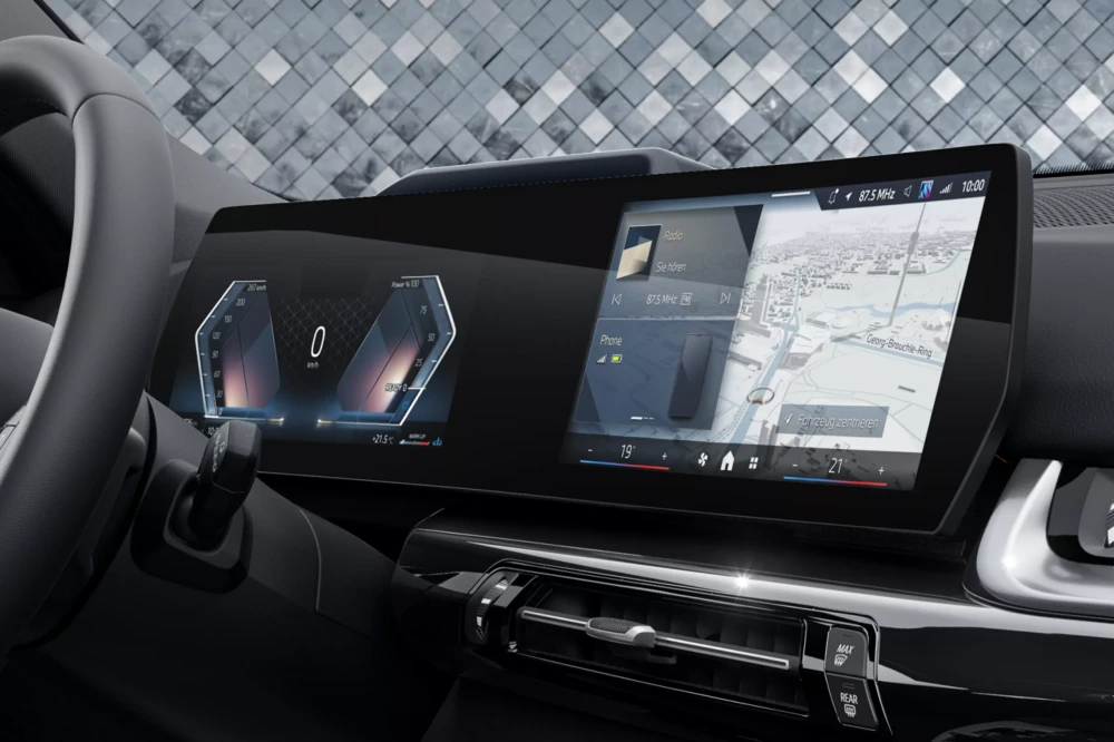 BMW X1 xDrive25e plug-in şarj edilebilir hibrit SUV otomobilin modern iç mekan tasarımında, sürücüye dönük kavisli geniş dijital panelde hız göstergesi, güç bilgileri, radyo, telefon ve detaylı navigasyon haritası gibi birçok bilgi akıcı bir şekilde gösteriliyor.