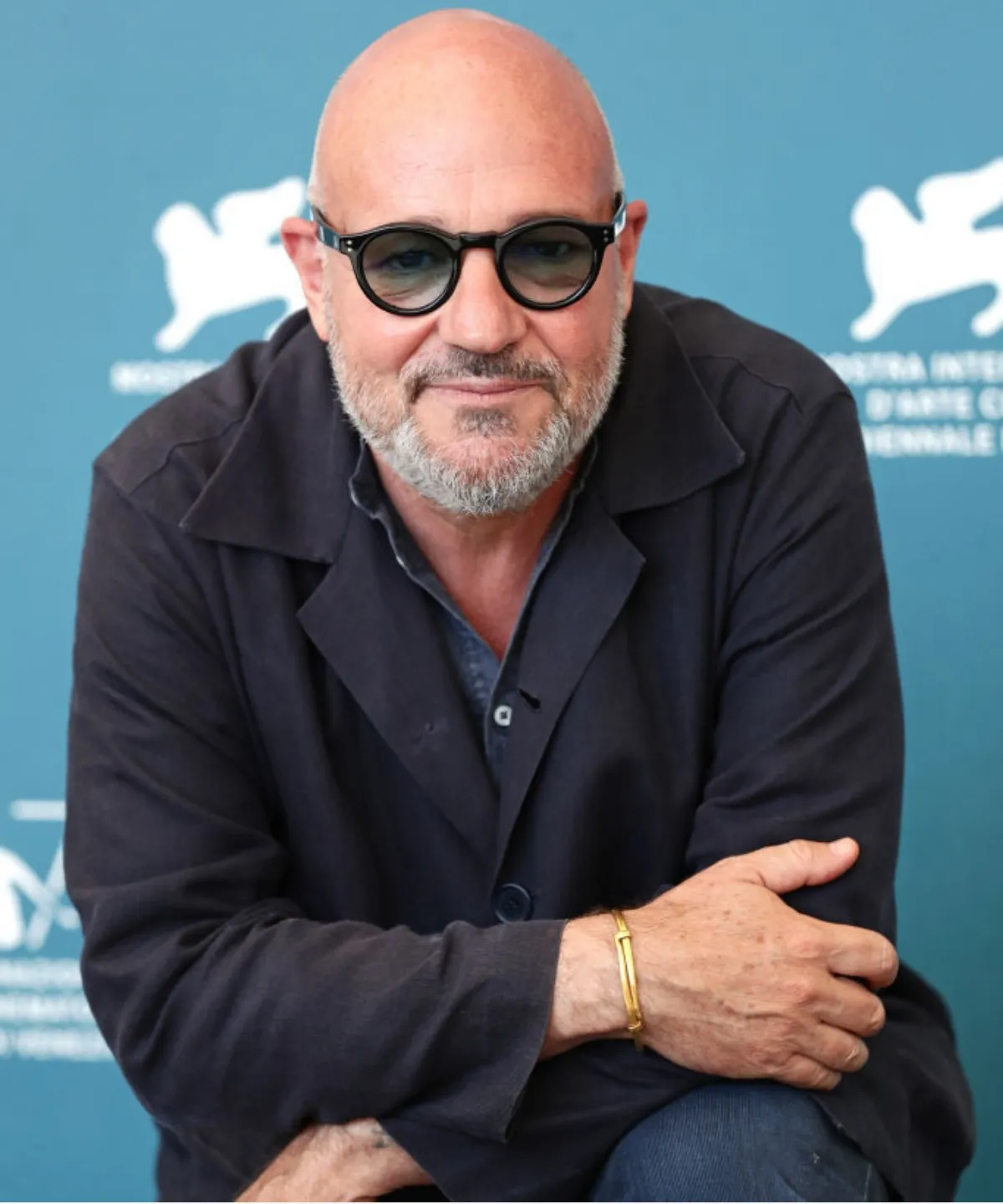 Sinema yönetmeni Gianfranco Rosi, gri sakalı, şık yuvarlak siyah gözlükleri, koyu renk ceketi ve sol bileğindeki altın bileklikle, arkasında Venedik Film Festivali'nin simgesinin belirsizce göründüğü turkuaz bir fonda ciddi bir ifadeyle poz veriyor: 45. İstanbul Film Festivali Sinema Onur Ödülü.