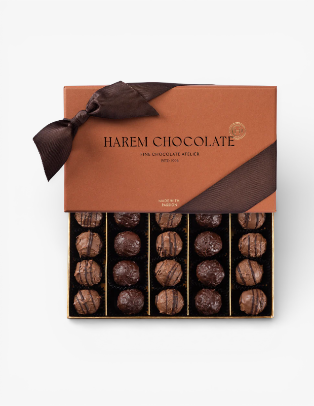 Harem Chocolate'ın kadınlara özel Sevgililer Günü hediye kutusu. Bakır renkli kutu, kahverengi kurdelesiyle açılmış, içinde özenle dizilmiş bitter ve sütlü çikolata trüfleri sergileniyor.