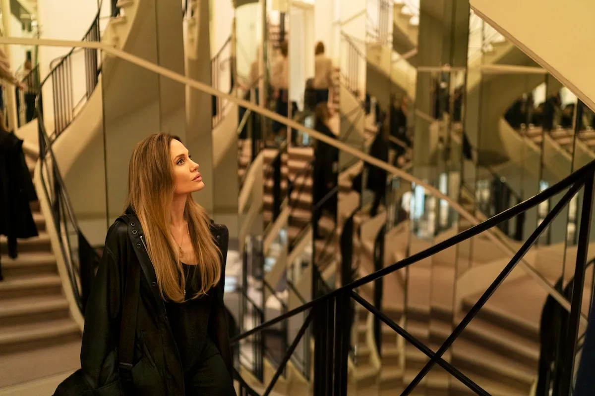 İstanbul Film Festivali: Angelina Jolie, şık siyah bir kıyafetle, etrafını saran aynalı merdivenlerin yarattığı büyüleyici yansımalar arasında yukarı doğru bakarken, bir film galası veya özel bir moda etkinliği atmosferini yansıtan zarif ve dramatik bir an sunuyor.