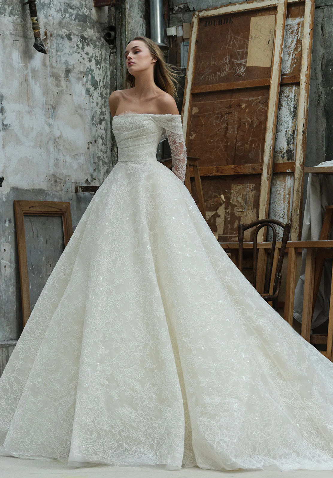 Elie Saab 2026 ilkbahar koleksiyonundan düşük omuzlu, ince dantel dokulu, hacimli etekli zamansız romantik gelinlik