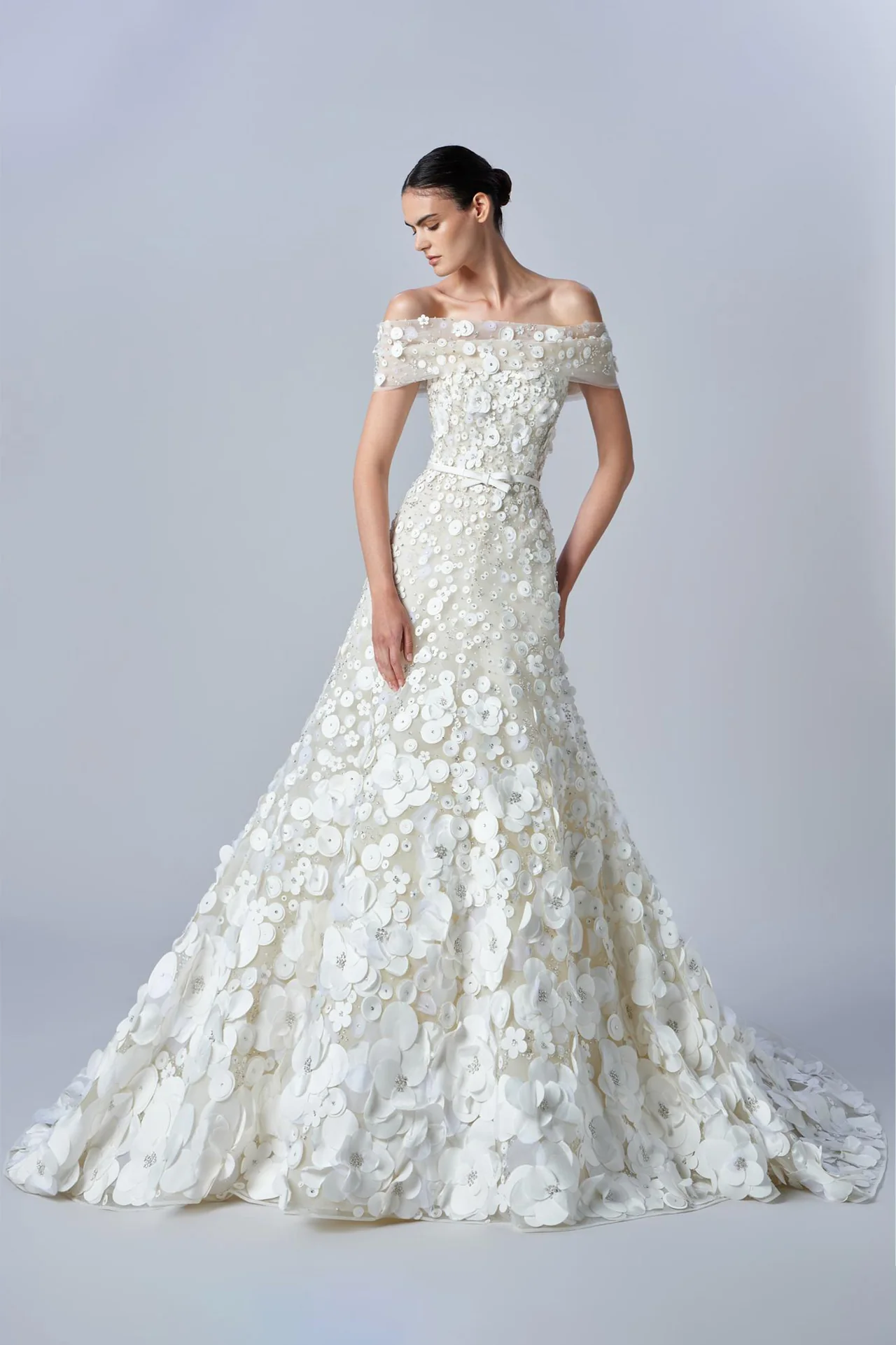 Elie Saab 2026 sonbahar koleksiyonundan düşük omuzlu, yoğun çiçek aplikeli, üç boyutlu dokulu romantik gelinlik.