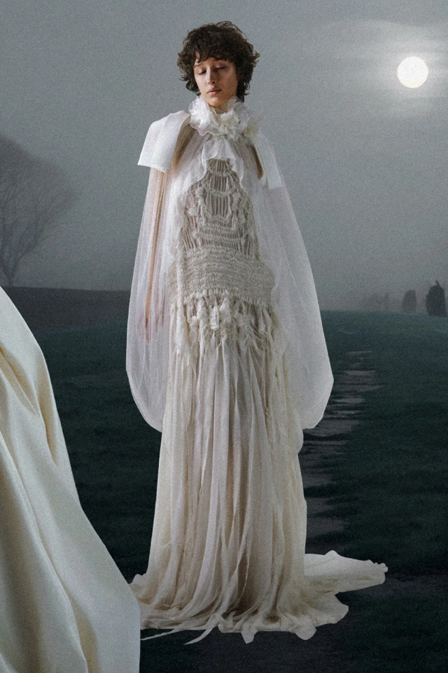 Vera Wang 2026 koleksiyonundan transparan katmanlı, püskül detaylı, avangart ve modern romantik gelinlik.