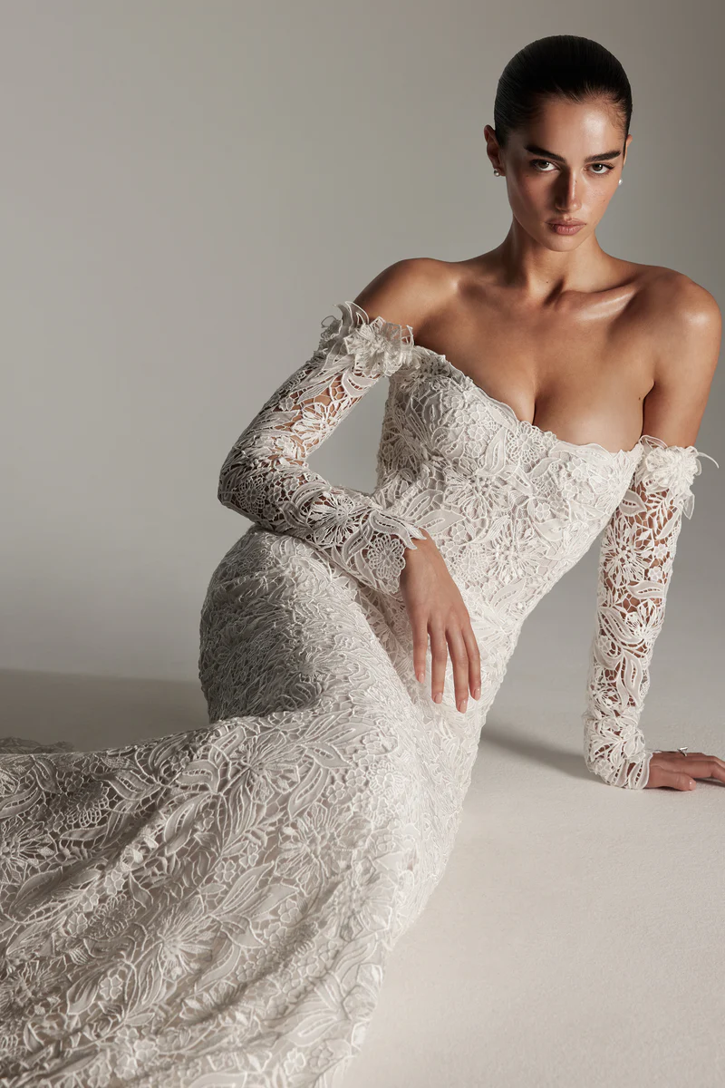 Monique Lhuillier uzun kollu, düşük omuzlu, tamamı dantel kaplı balık model gelinlik.
