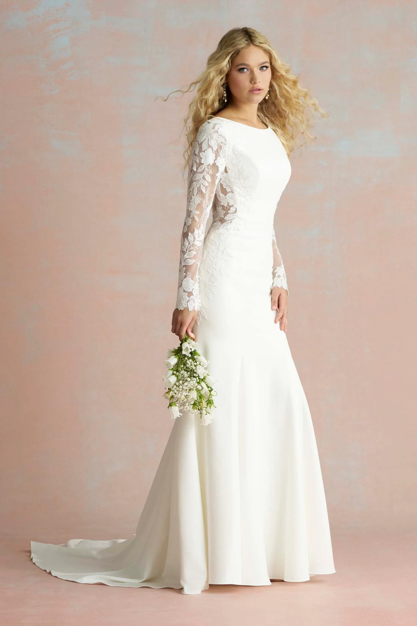 Allure Bridals marka, kayık yakalı ve tamamı zarif çiçek desenli dantel detaylı uzun kollara sahip bembeyaz bir uzun kollu gelinlik.