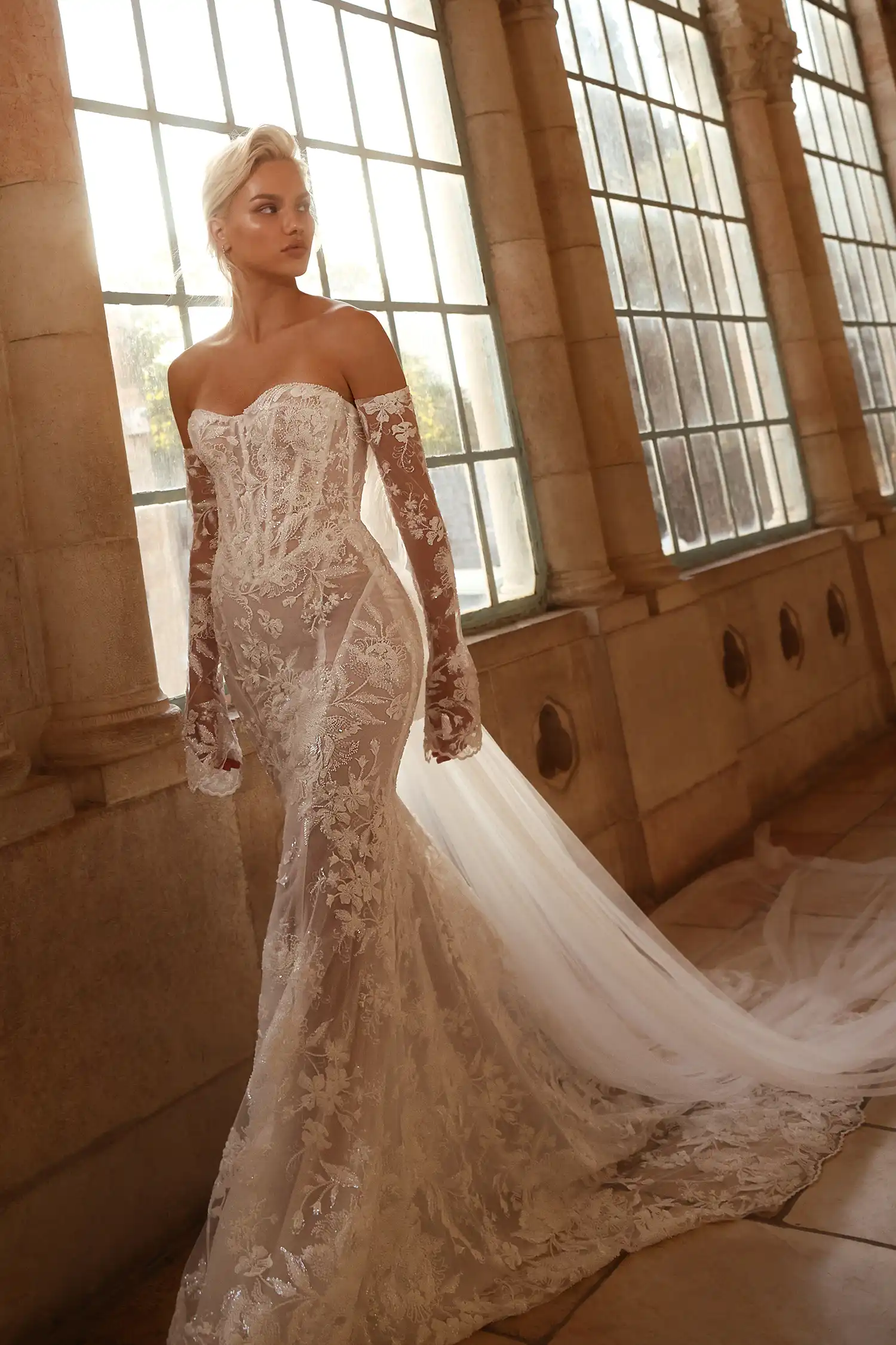Pnina Tornai uzun kollu, düşük omuzlu, floral dantel işlemeli şeffaf balık model gelinlik.