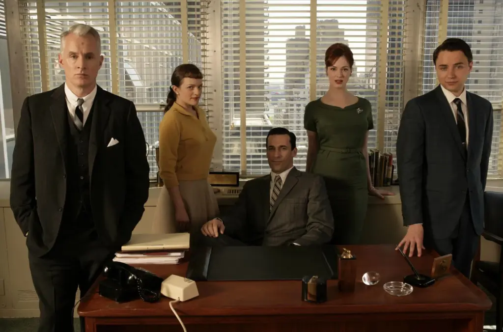 Yabancı diziler seçkisinde yer alan “Mad Men” dizisinin ana karakterleri 1960’lar ofis atmosferinde klasik kıyafetleriyle masa etrafında toplanmış halde.