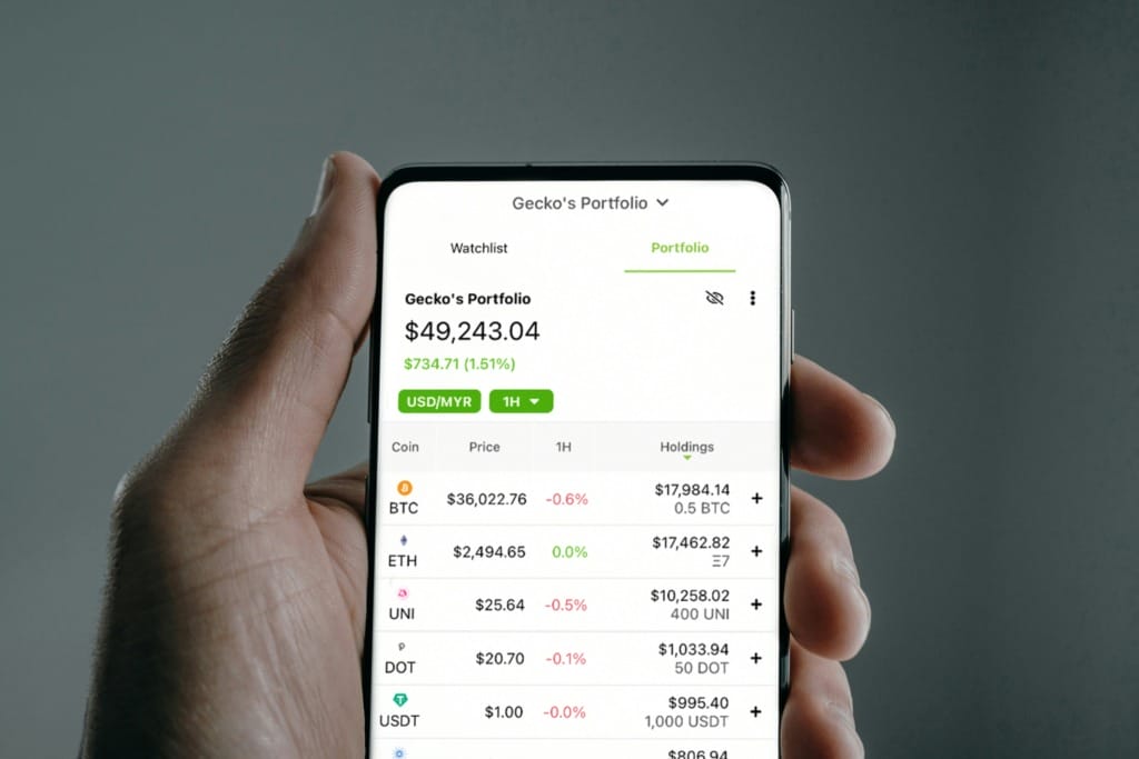 Cep telefonunda kripto para portföyü ekranı açık; BTC, ETH, UNI gibi varlıklar ve toplam portföy değeri görünüyor.