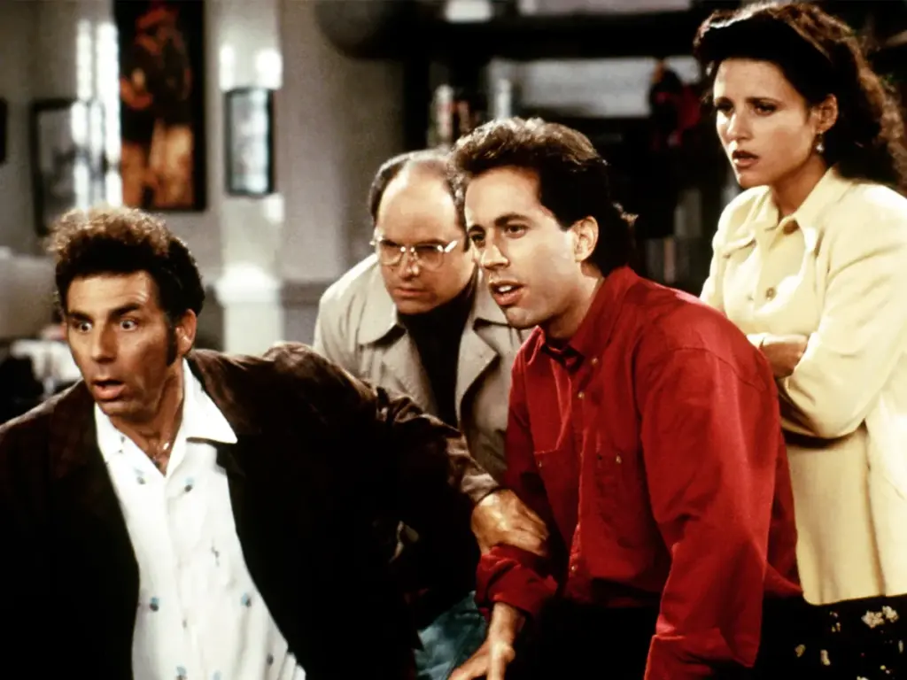 Seinfeld dizisinin efsane dörtlüsü Kramer, George, Jerry ve Elaine şaşkın bir ifadeyle bir noktaya bakıyor.