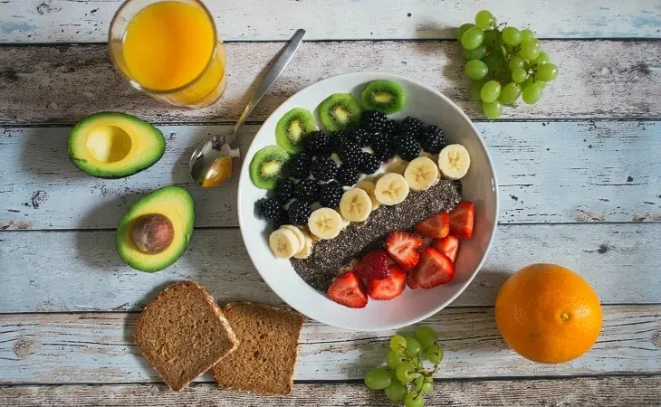 Chia tohumlu smoothie kasesi; muz, kivi, böğürtlen, çilek, avokado, üzüm ve tam buğday ekmeği ile dengeli vegan kahvaltı sofrası.