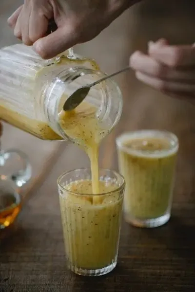 Ev yapımı meyve ve chia tohumlu smoothie karışımı bardağa dökülürken; sağlıklı vegan içecek ve doğal beslenme rutini temalı görsel.