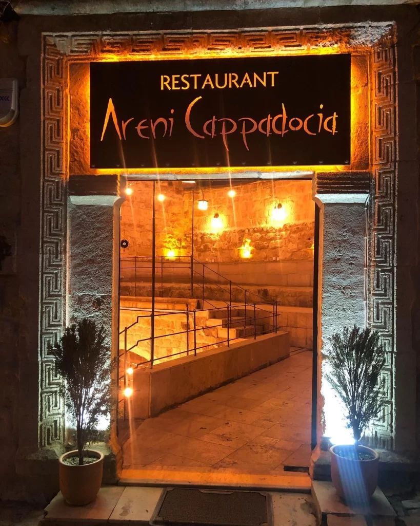 Ürgüp’teki Areni Restaurant’ın taş duvarlı, sıcak ışıklandırmalı giriş kapısı