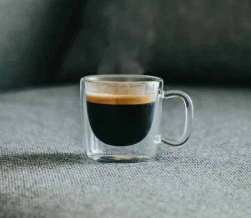 Cam kulplu bardakta servis edilen lungo kahve, kremalı üst yüzeyiyle yakın çekim