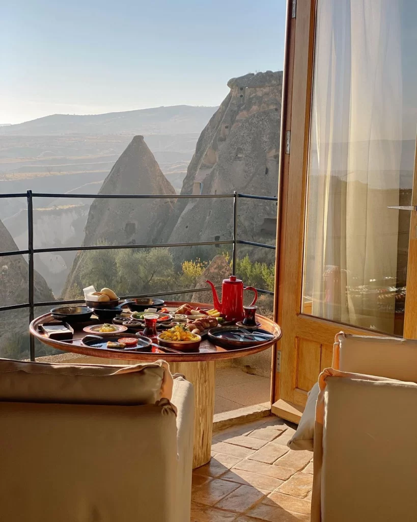 Millstone Cave Suites’te Kapadokya peri bacaları manzaralı balkonda sunulan geleneksel kahvaltı
