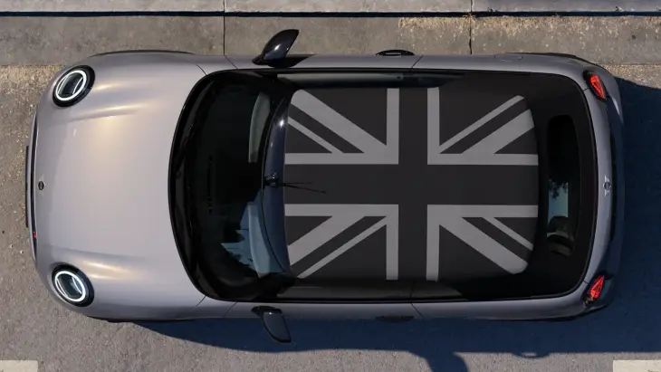 Yeni MINI Cooper Cabrio modelinin gri renkli gövdesini ve ikonik Union Jack desenine sahip açılır tavanını kuşbakışı gösteren bu fotoğraf, şehir sokaklarında özgürlük rüzgarını estirecek modern ve dikkat çekici tasarımını gözler önüne seriyor.