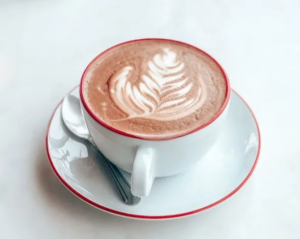 Latte art süslemeli beyaz fincanda mocha kahve, çikolatalı sütlü kahve sunumu