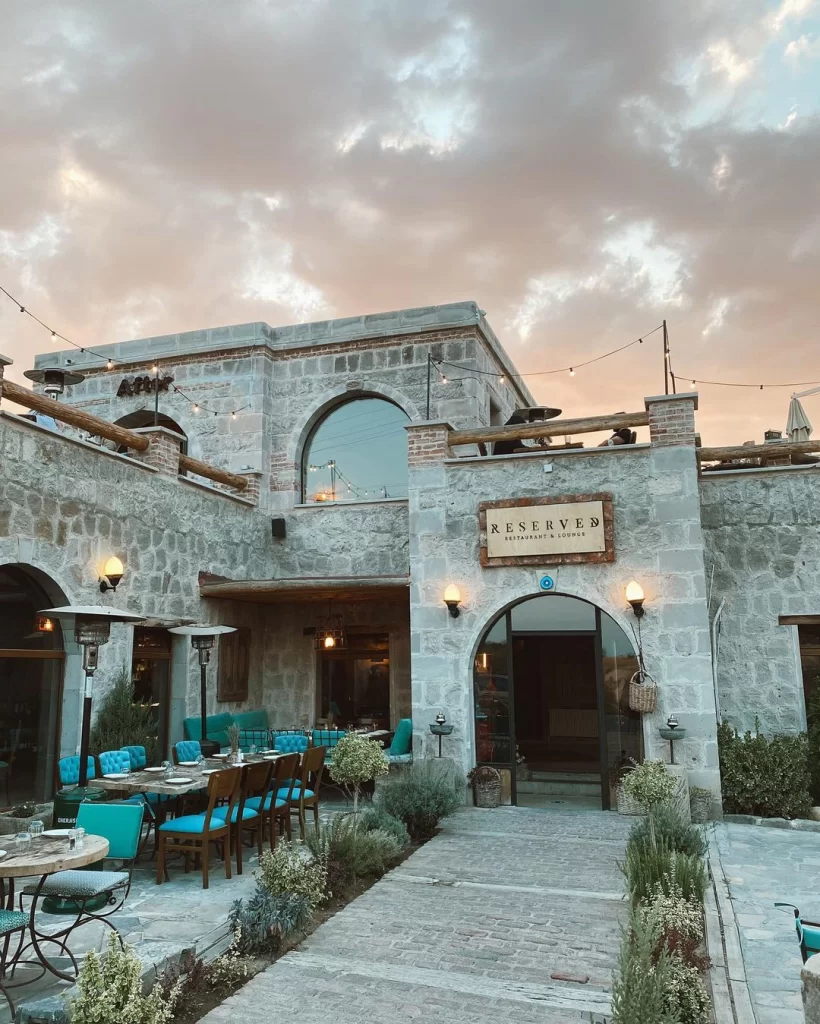 Kapadokya’da Güvercinlik Vadisi yakınında yer alan Reserved Restaurant & Lounge’un taş mimarili dış mekânı ve şık bahçesi