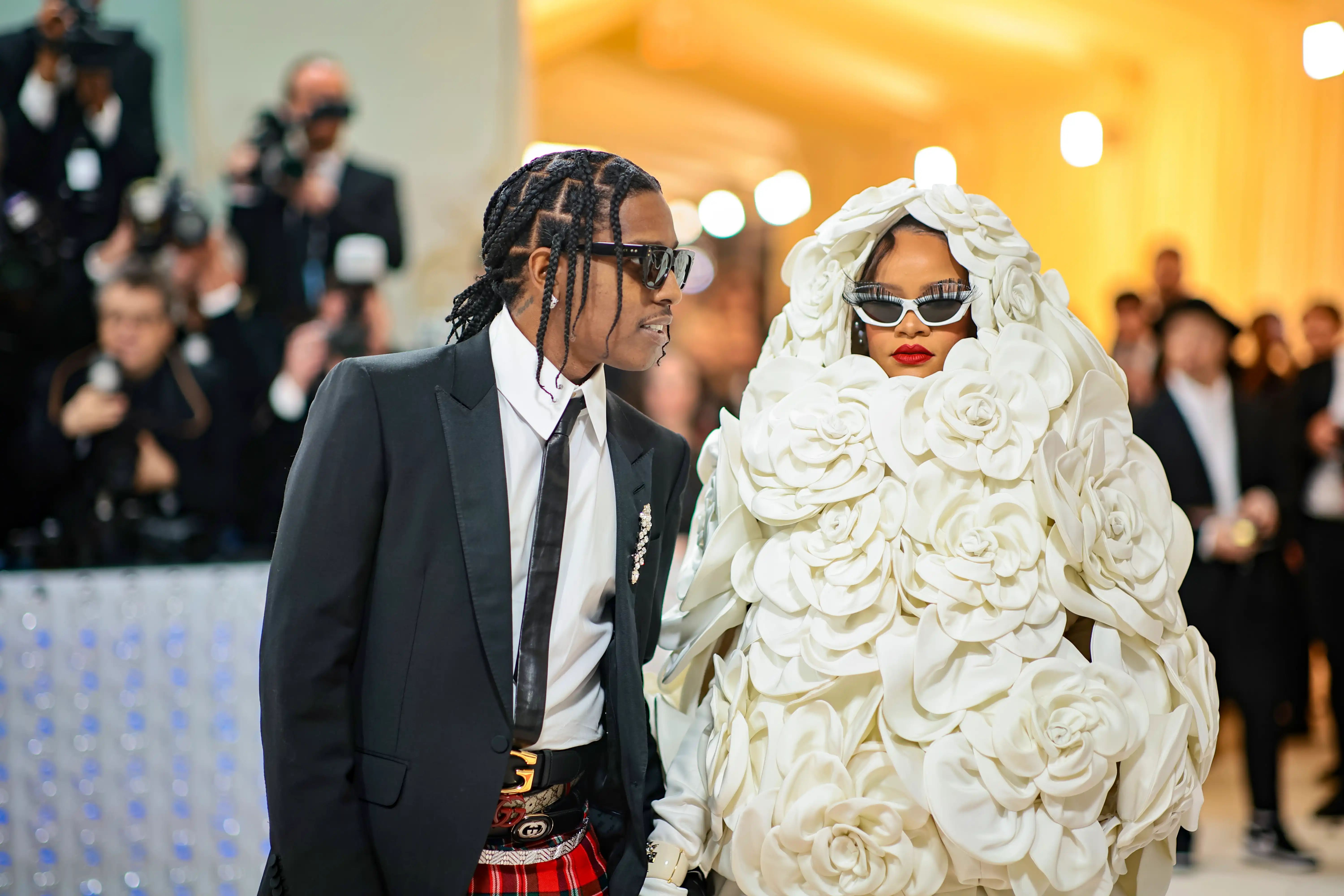 Moda dünyasının en prestijli etkinliklerinden Met Gala'da, A$AP Rocky siyah takım elbisesi, ekose eteği ve örgülü saçlarıyla, Rihanna ise ikonik kırmızı ruju, dramatik güneş gözlükleri ve beyaz gül benzeri hacimli elbisesiyle dikkat çekiyor.