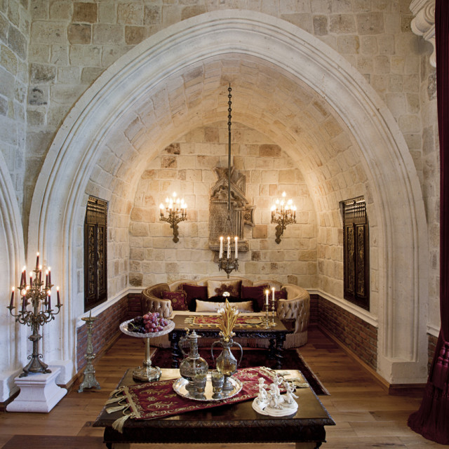 Sacred House otelin gotik kemerli taş duvarlı, şamdanlarla süslenmiş oturma alanı