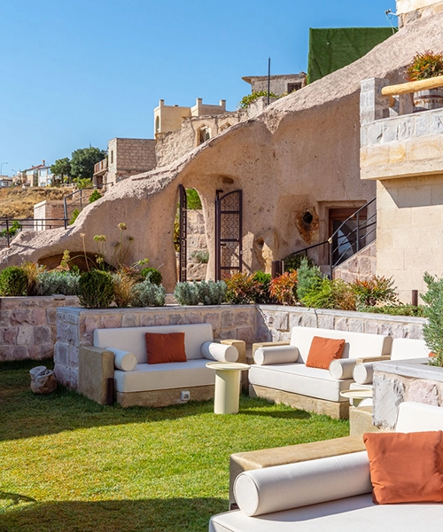 Taşkonaklar Hotel’in mağara konseptli taş yapılarıyla çevrili yemyeşil bahçesi ve rahat oturma alanları