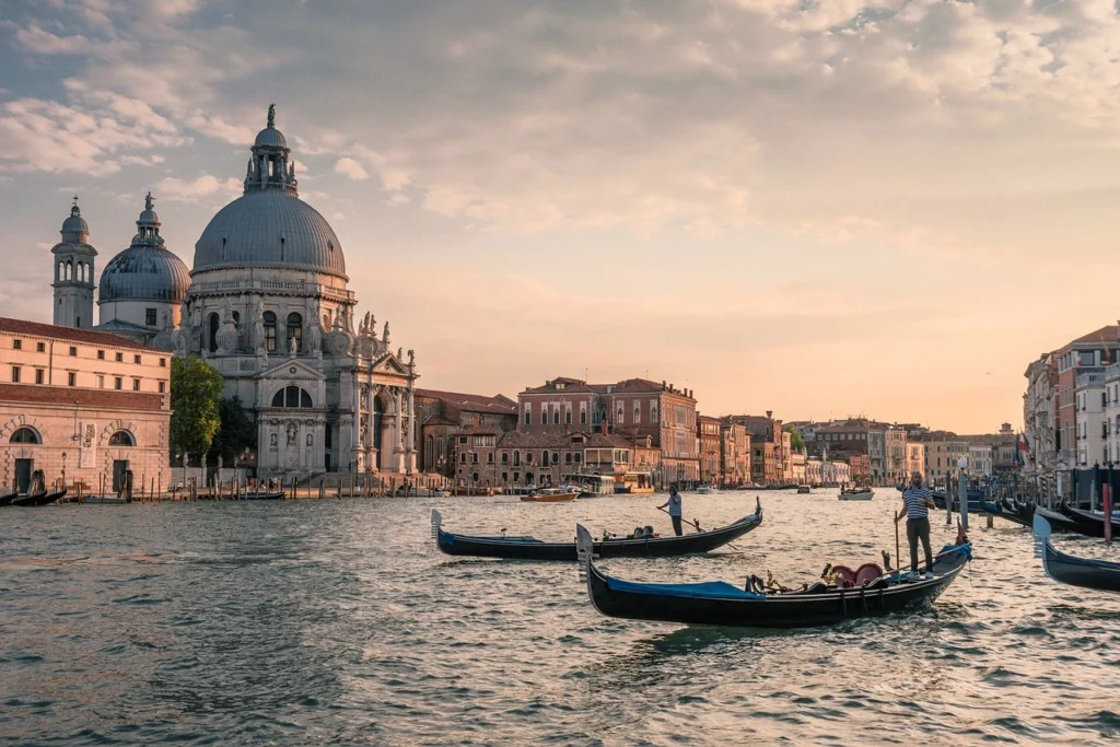 Venedik’te gün batımında gondollar ve Santa Maria della Salute Bazilikası – Büyük Kanal manzarası