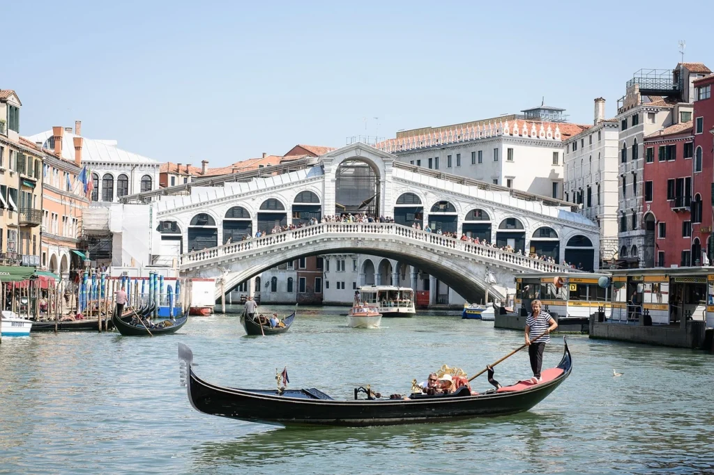 Venedik’in ünlü Rialto Köprüsü ve Büyük Kanal üzerinde gondol gezisi yapan turistler