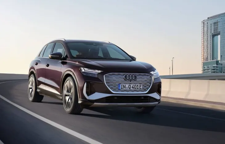 Audi Q4 e-tron modeli şehir içi yolda ilerlerken, modern tasarımı ve aerodinamik hatlarıyla öne çıkıyor.